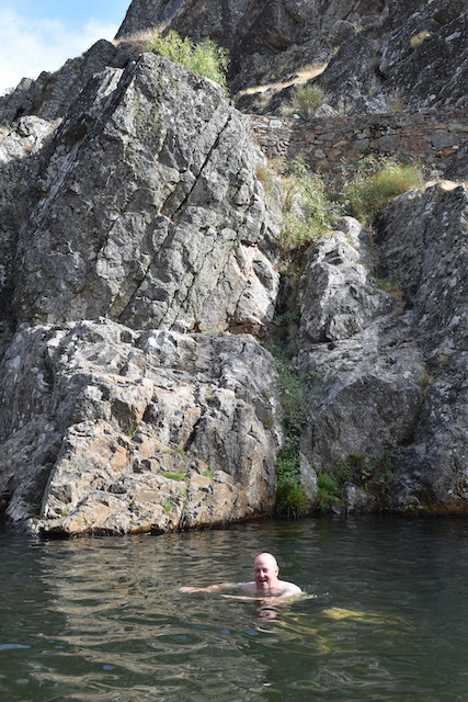 man swimming in rock pool