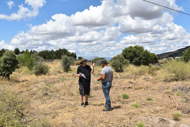 two men talking in field of very dry grass
