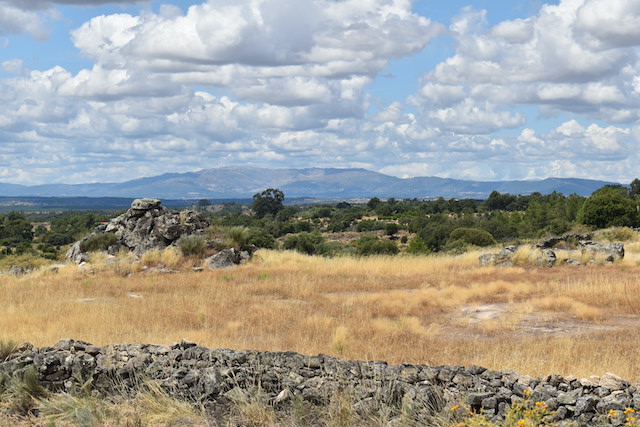 view of blue tinged mountains across dry fields