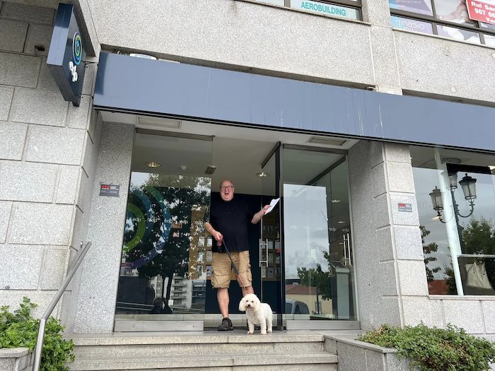 Man looking very happy standing on steps of office with dog