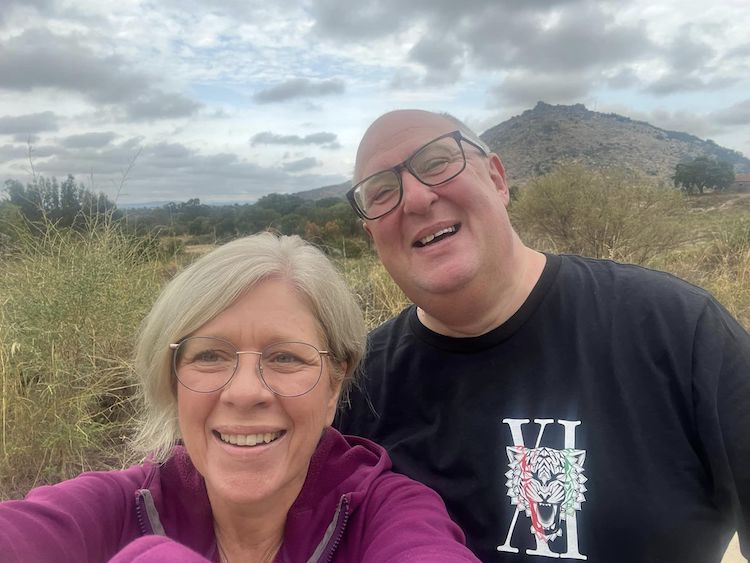 smiling man and woman in front of mountain